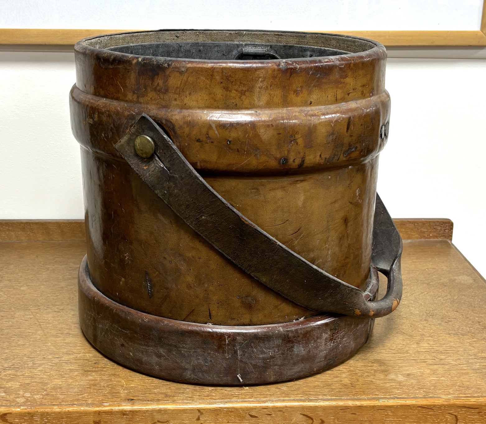 A Victorian tan leather shot carrier with applied royal crest and tin liner, diameter 35cm, height 34cm